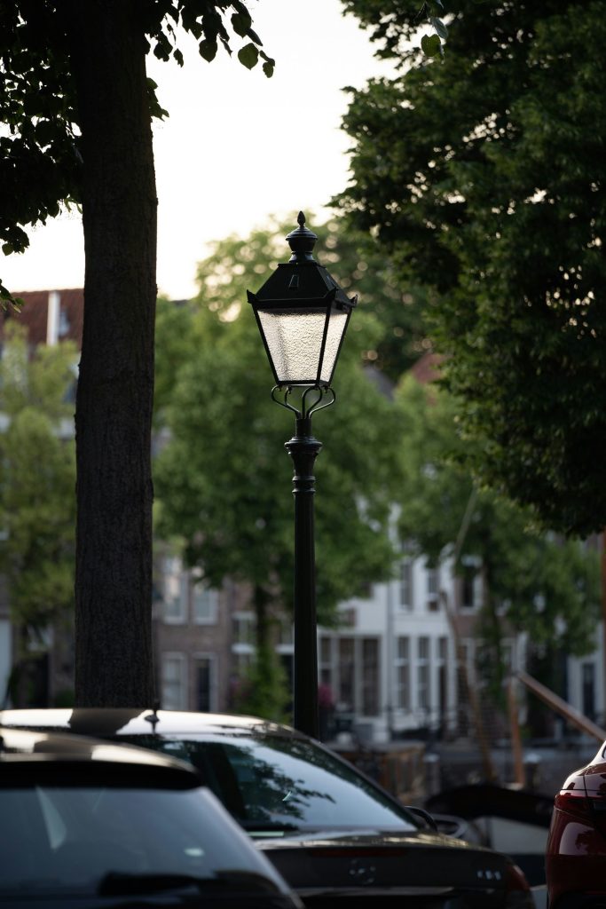 a lamp post on a city street next to parked cars